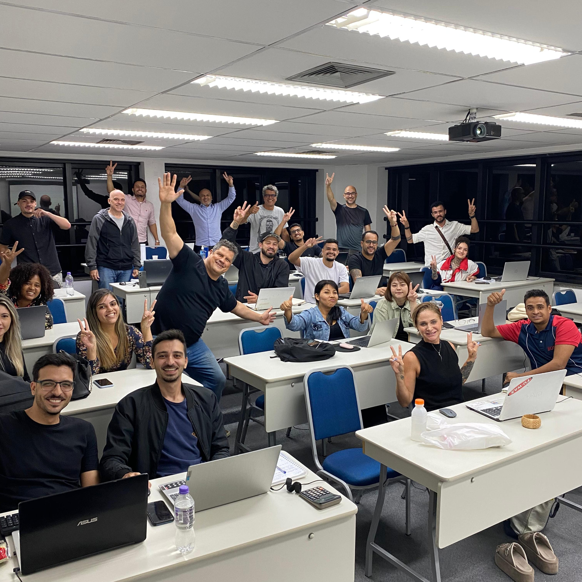 Alunos da imersão presencial de tráfego pago do Prof. Fábio JP comemorando em sala de aula.